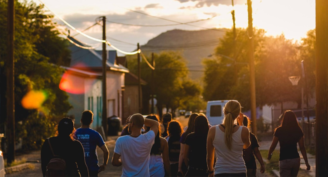 Students walking down street in Arizona border town at sunset